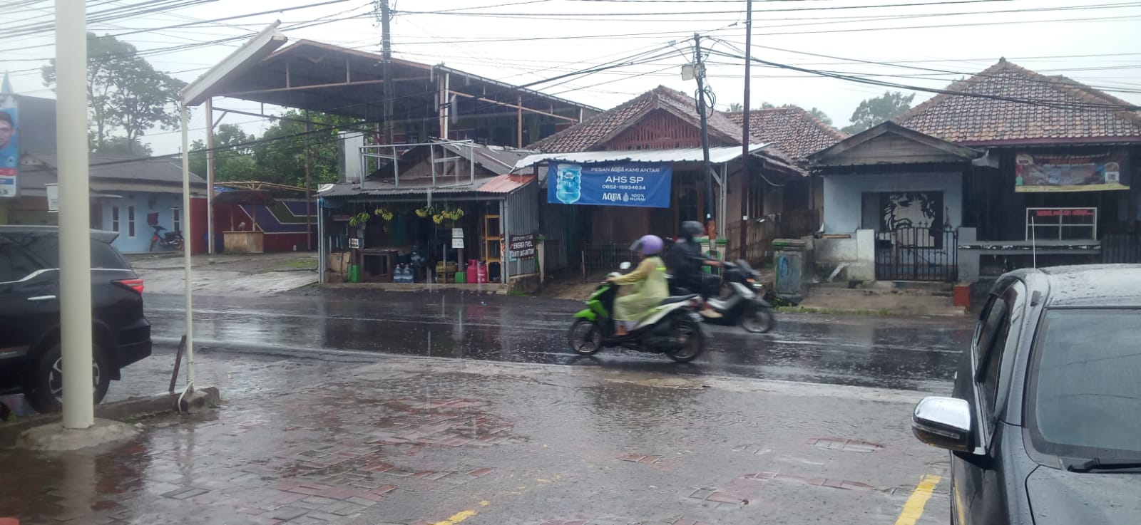 Berpergian Kenakan Jas Hujan, Curah Hujan di Pandeglang Lebat, BMKG: Warga Diminta Waspada 