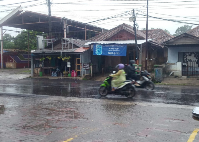 Berpergian Kenakan Jas Hujan, Curah Hujan di Pandeglang Lebat, BMKG: Warga Diminta Waspada 